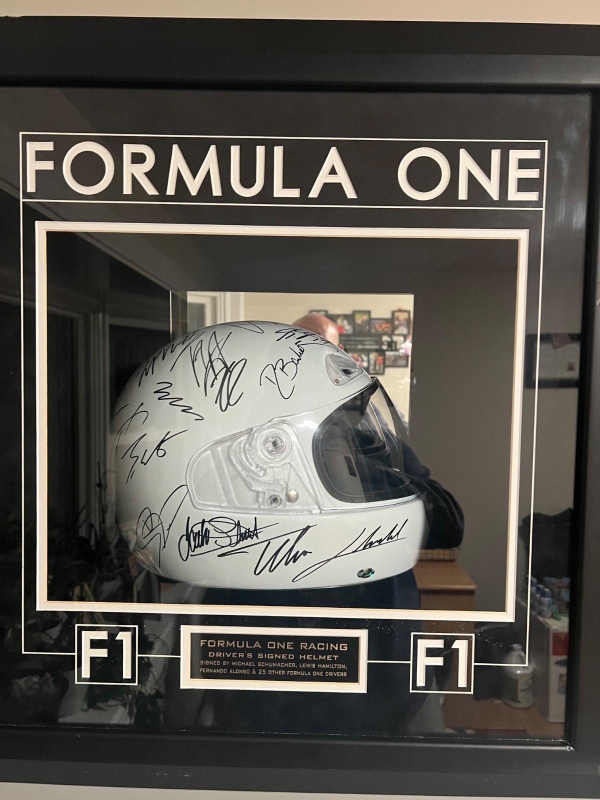 Framed Formula 1 memorabilia featuring a signed white helmet Framed Formula 1 memorabilia featuring a signed white helmet